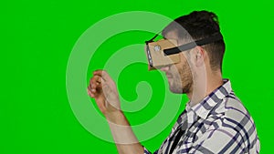 Man wearing virtual reality goggles. Green scree. Close up