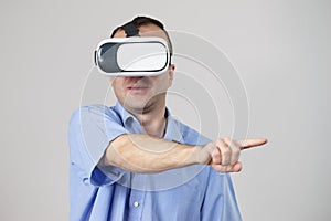 Man wearing virtual reality goggles on grey