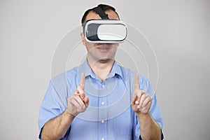 Man wearing virtual reality goggles on grey