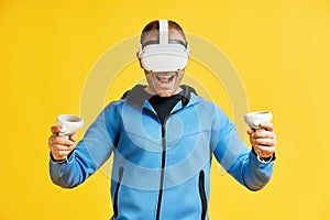 Man wearing virtual reality goggles over yellow background