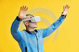 Man wearing virtual reality goggles over yellow background