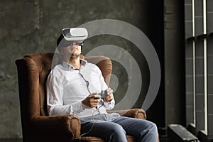 Man wearing virtual reality goggles watching movies or playing video games. The vr headset design is generic and no logos