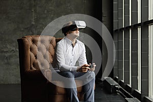 Man wearing virtual reality goggles watching movies or playing video games. The vr headset design is generic and no logos