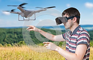 Man wearing virtual reality headset is controlling a flying drone