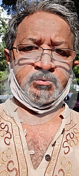 Man wearing virus protection face mask over chin and neck