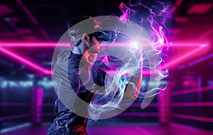 Man wearing VR glass and punching at camera in neon boxing arena. Deviation.