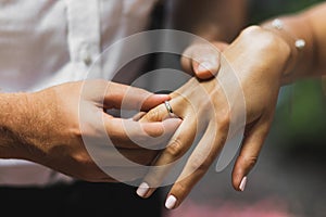 Man wearing wedding ring on woman hand close up. Wedding ceremony vows.