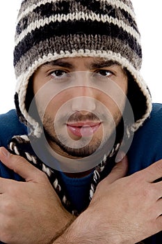 Man wearing winter cap shivering from cold