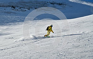 Man wearing yellow suit snowboarding down at extreme double diamond area at Emperial bowl.
