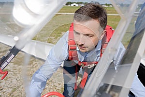 Man wearning harness climbing up