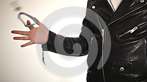 Man wears a black leather jacket and spins keys on his fingers