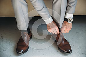 Man wears shoes. Tie the laces on the shoes. Men`s style. prepare for work, to the meeting