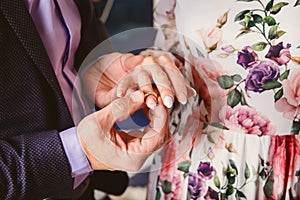 A man wears a wedding ring on the finger of the bride