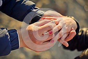 Man wears a wedding ring on woman's hand