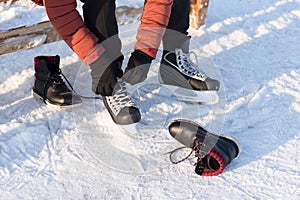 Man wears a winter skates at the rink