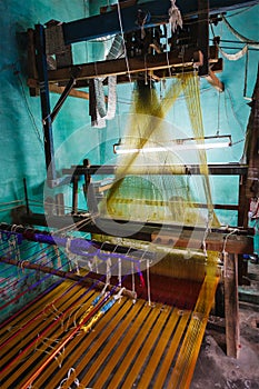 Man weaving silk sari on loom in India