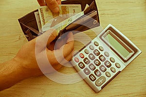 Man weeds off cash out of his wallet. Wealthy man counting his money