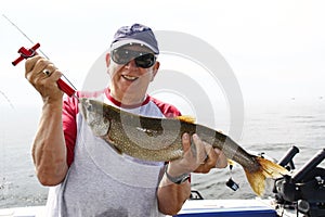 Man Weighing Large Fish - Lake Trout photo