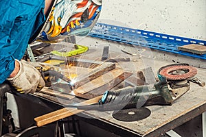 Man weld a metal welding machine in a workshop