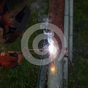 A man welder welds with a welding machine photo