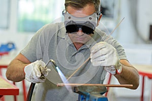 Man welding copper with blowtorch