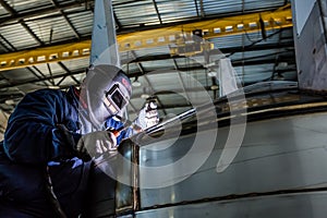 Man welding with reflection of sparks on visor