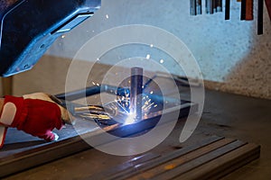 Man welding steel frames in a forgery and metal works workshop