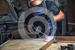 Man welds a metal arc welding machine