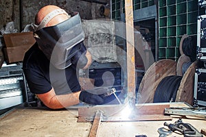 Man welds a metal arc welding machine