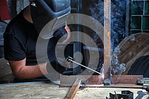 Man welds a metal arc welding machine