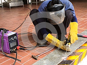 A man welds a metal with a welding job photo