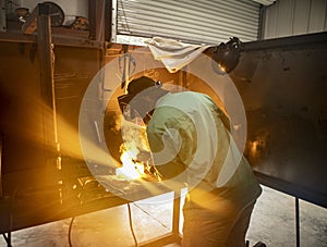 A man welds two pieces of metal together in a shot with an arc welder