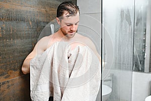 Man with wet hair hold towel after shower. Morning washing, wake up, everyday life. Refreshment, healthcare. Hygiene