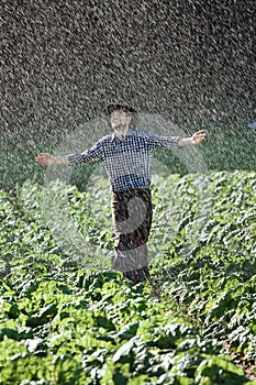 Man wet under rain farmer hat enjoy prayer happy upset heavy wet water shower sun summer pray