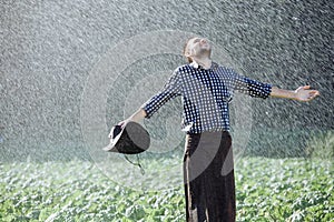 Man wet under rain farmer hat enjoy prayer happy upset heavy wet water shower sun summer pray