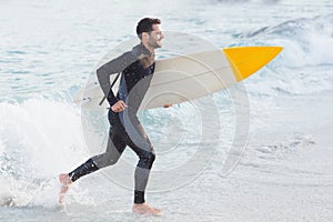 Man in wetsuit with a surfboard on a sunny day