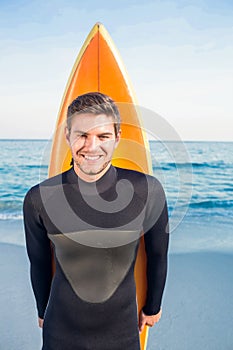 Man in wetsuit with a surfboard on a sunny day