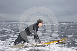 Man In Wetsuit Surfing At Beach