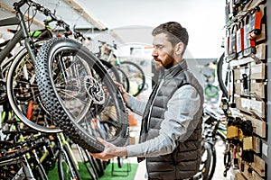 Man with wheel at the bicycle shop