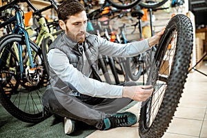 Man with wheel at the bicycle shop