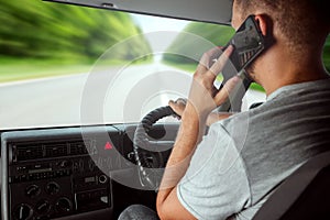 A man at the wheel holding a smartphone in his hand, violates traffic rules. The concept of an accident, a traffic violation, the