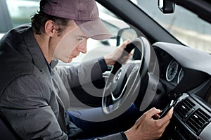 Man at wheel using cell mobile phone while driving car
