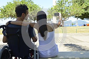 Man in wheelchair and girlfriend taking selfie