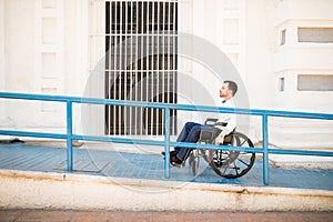 Man in wheelchair going up a ramp