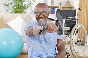 man in wheelchair holding dumbbell in hand