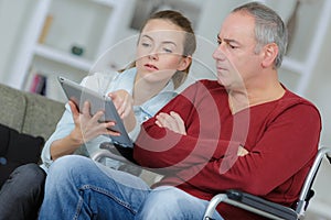 Man in wheelchair learning to use tablet