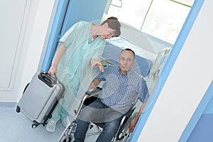 Man in wheelchair leaving hospital