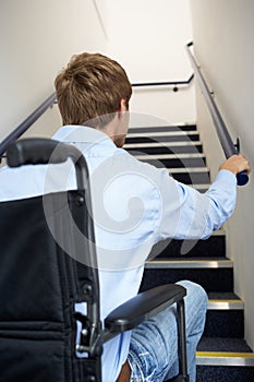 Man in wheelchair looking up at stairs