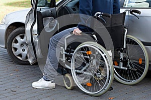 Man in wheelchair next to car