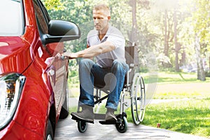 Man On Wheelchair Opening Car Door